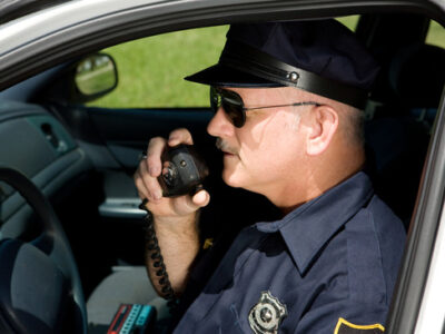 Police Officer on Radio Police officer in squad car talking on his radio. Closeup view.
