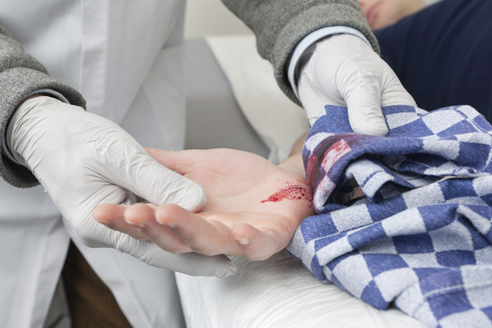 Doctor Cleaning a Bleeding cut With Cloth